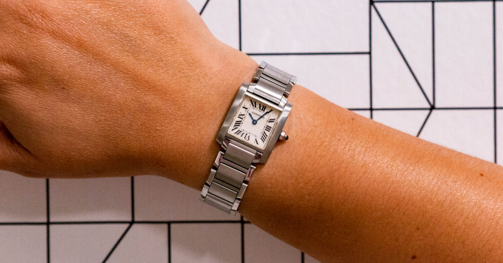 A woman wearing a Cartier Tank Francaise watch.