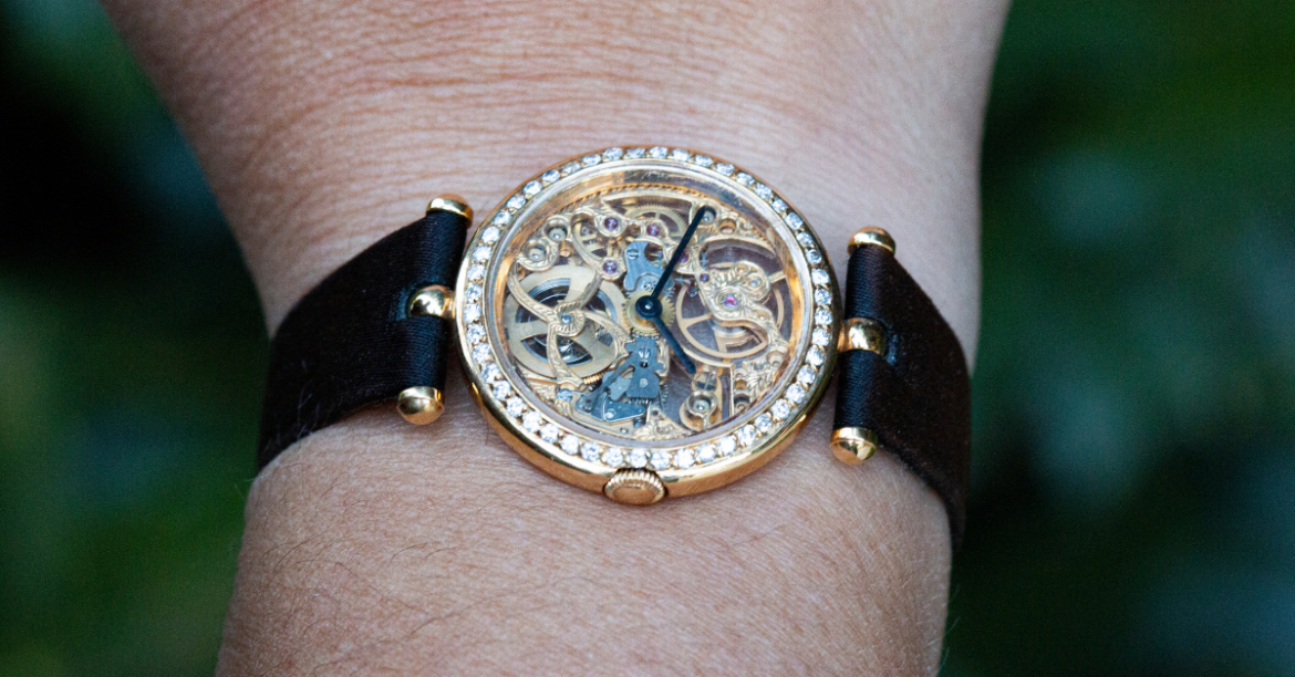 van cleef and arpels 18K yellow gold skeleton watch with a black band